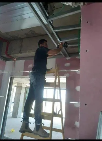 איש מקצוע עובד על מסגרת מתכת לתשתיות תקרה