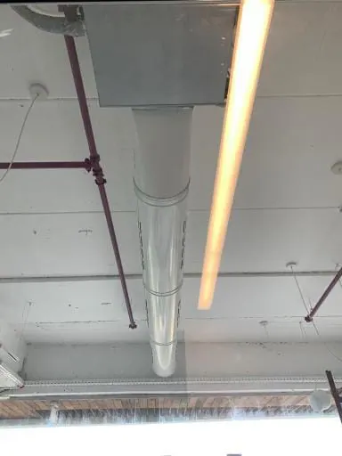 תעלת אוויר עגולה חשופה לאורך תקרת חלל מסחרי